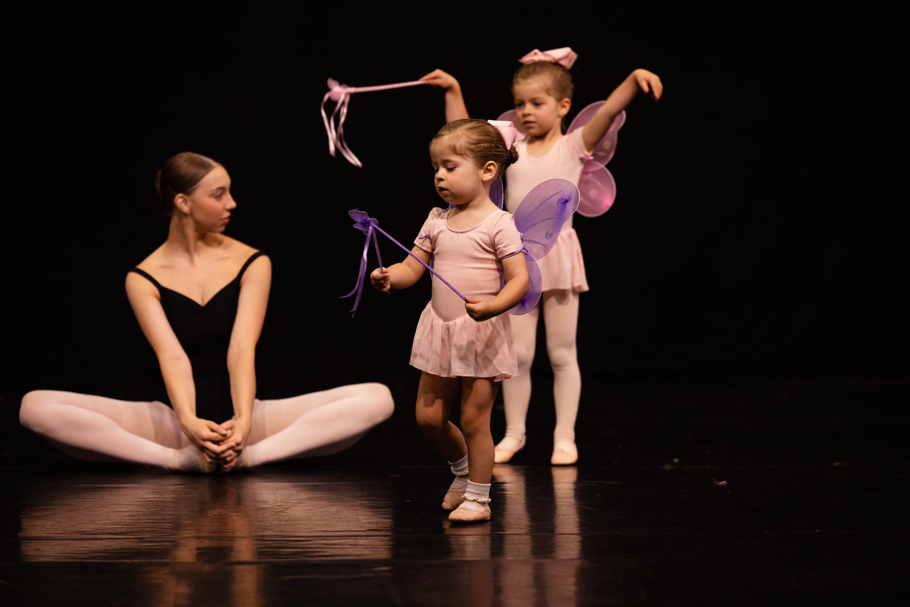 Teacher with tiny dancers on stage